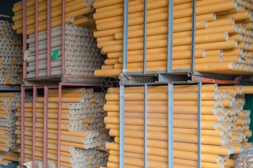 一堆纸管芯和组织积在工业制造厂的中棕色纸卷的原始产品材料库存车间